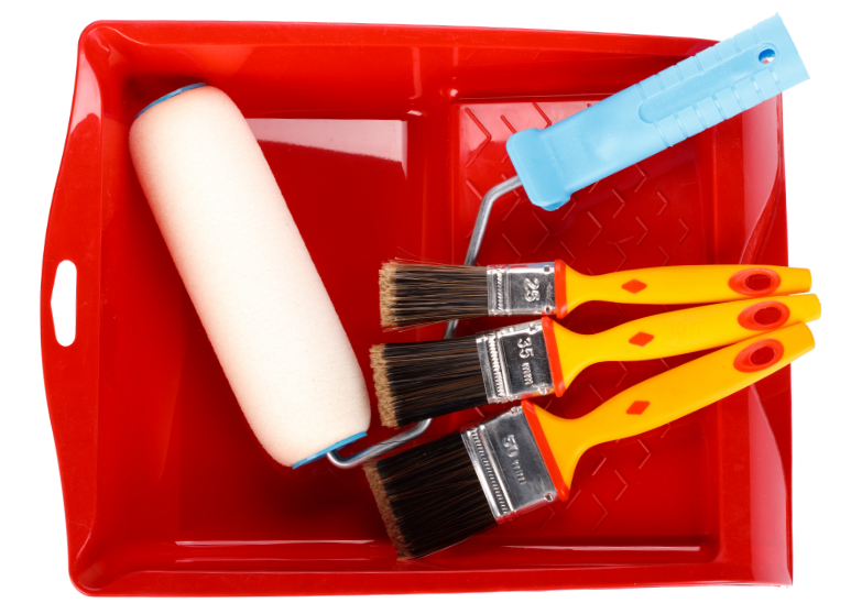 A red paint tray containing a foam roller with a light blue handle and three paintbrushes with orange handles, ideal for interior or exterior jobs. The brush handles are marked with sizes: 1.5, 2, and 2.5 inches. The tray has a textured area for removing excess paint.